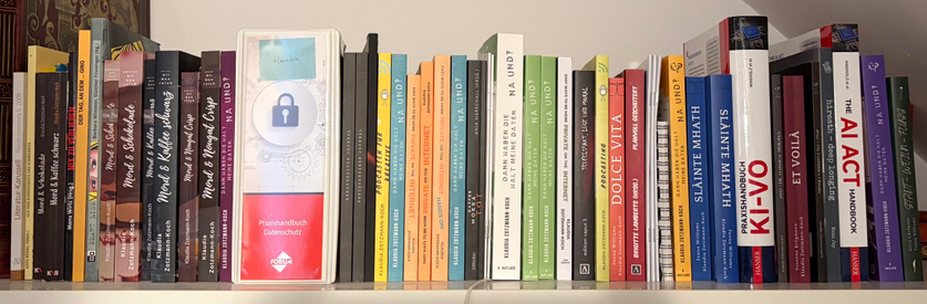 Photo of a shelf of books that were either entirely written by me or have short stories or articles by me inside, sorted chronologically from left to right. 