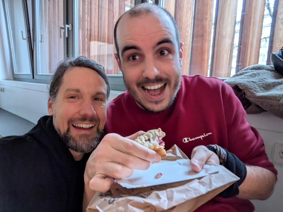 two people, one of them eating a small cake