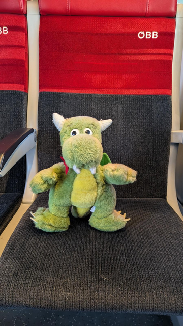 KDE mascot Konqi on a train seat