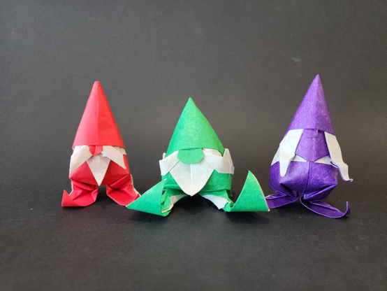 trois lutins en origami. à gauche : lutin en version debout. au milieu : lutin en version assis. à droite, lutine en version debout.