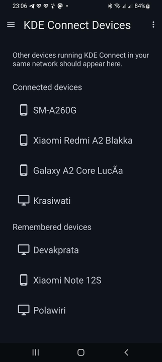The image shows a mobile device screen displaying Konnect "KDE Connect Devices" interface. The background is dark, and the text is white, providing a clear contrast. At the top, the time is shown as 23:06, with various status icons indicating Bluetooth, Wi-Fi, and battery level at 84%. The main title "KDE Connect Devices" is prominently displayed, followed by a message stating that other devices running KDE Connect in the same network should appear here.

Below this, there is a section titled "Connected devices," listing four devices: "SM-A260G," "Xiaomi Redmi A2 Blakka," "Galaxy A2 Core Lucã," and "Krasiwati," each accompanied by a device icon. The "Remembered devices" section follows, listing three devices: "Devakprata," "Xiaomi Note 12S," and "Polawiri," each with a corresponding icon. The interface is designed for easy navigation, with a menu icon on the left and a back arrow on the right, indicating the ability to return to the previous screen.

 Ovis2-8B

🌱 Energy used: 0.264 Wh