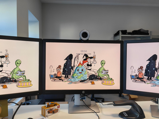 3 Bildschirme in einem Büro mit einer War and Peas Wallpaper.